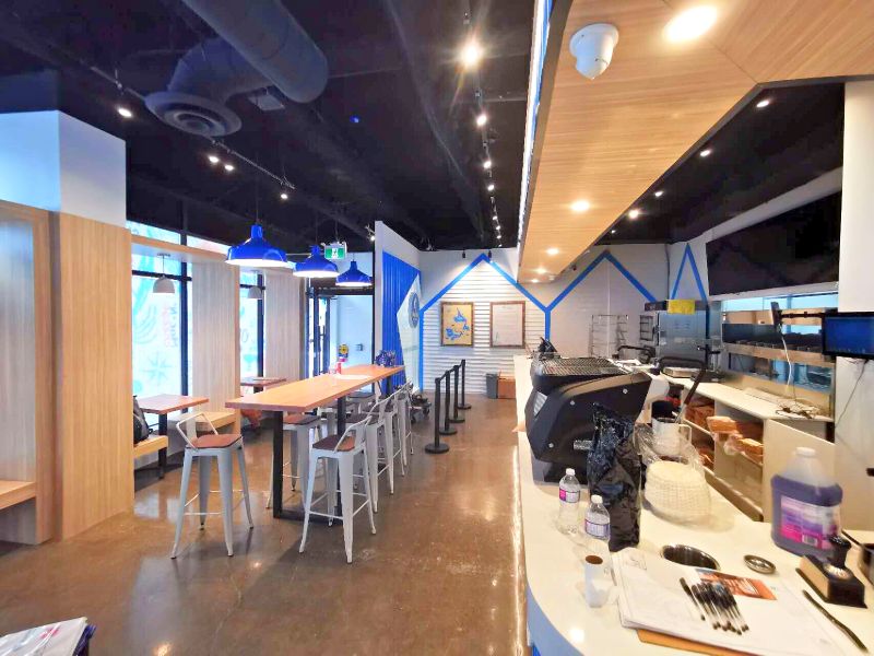 Long view of the restaurant with high-top tables, wood booths and track lighting
