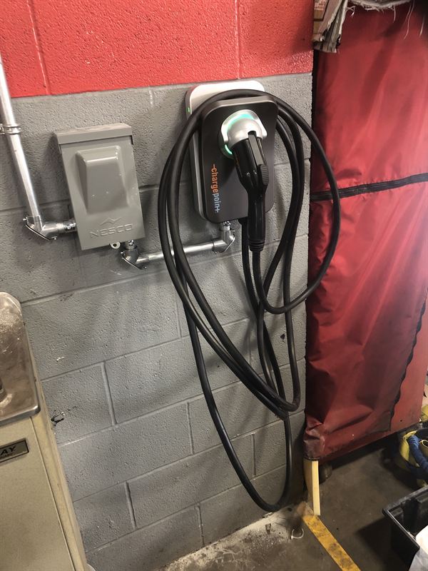 Level 2 EV charger on the wall of a dealership service shop