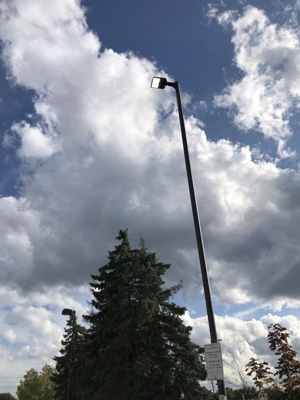 LED area light on a tall pole over a retail plaza parking lot