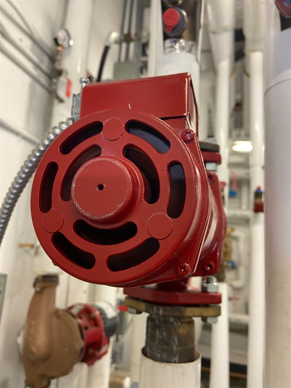 Red in-line domestic hot water recirculation pump on insulated piping
