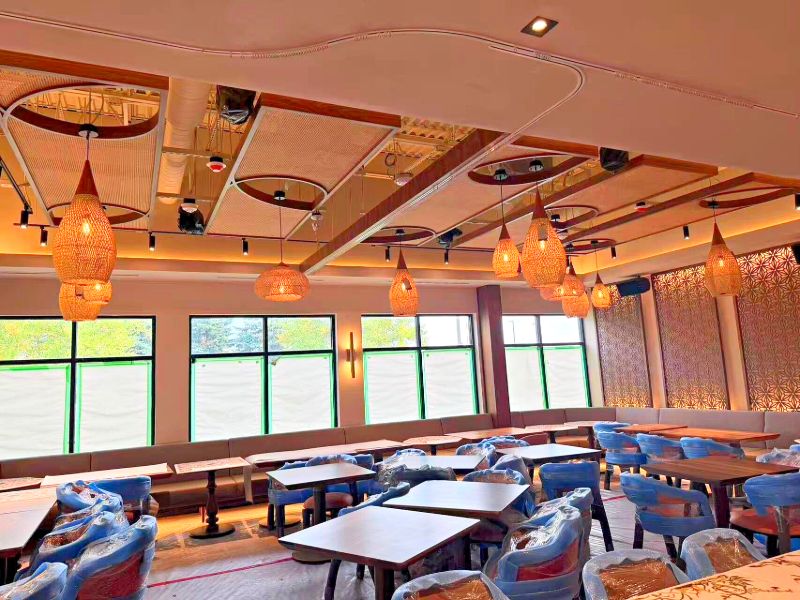Restaurant dining room lit by woven pendant lights